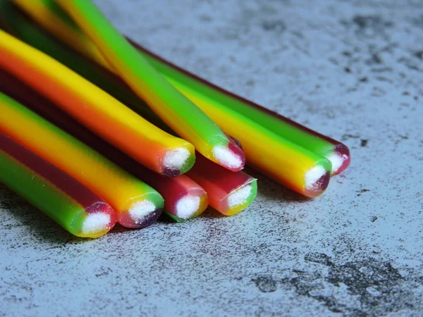 Colored fruit candy sticks. Candy-colored pencils. Copy space.
