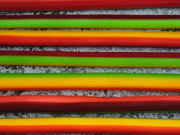 Colored fruit candy sticks. Candy-colored pencils. Copy space.