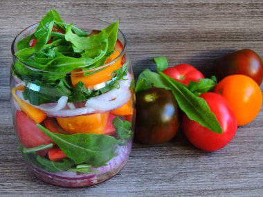 Renkli domates ve roka kavanozunda salata..