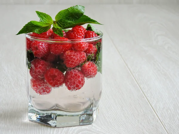 Refreshing detox drink with raspberries and mint. Raspberry mint water. Beverage for weight reduction. The concept of weight loss and a good figure.