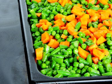 Pişirmek için tavada pişirmeden önce dilimlenmiş sebzeler. Havuç, taze bezelye, taze fasulye. Sağlıklı beslenme kavramı.