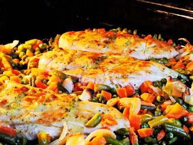 Tabakta sebzeyle pişirilmiş tavuk göğsü. Taze bezelye, havuç, taze fasulye. Sağlıklı beslenme ve yaşam tarzı kavramı.