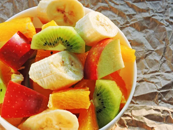 Färsk Saftig Fruktsallad Vit Skål Bakgrund Skrynkligt Papper — Stockfoto