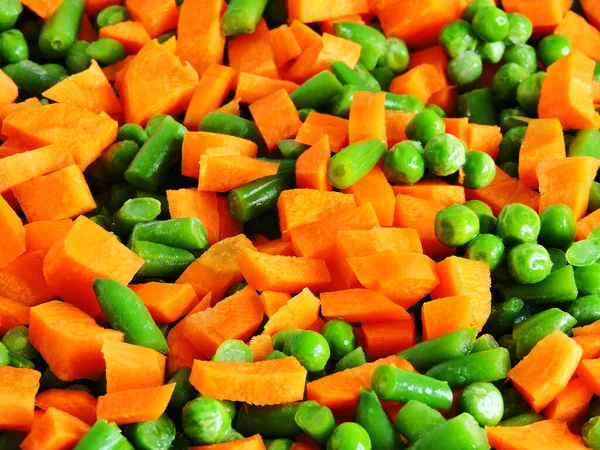 Sliced vegetables before baking on the Pan for baking. Carrots, green peas, green beans. The concept of a healthy diet.