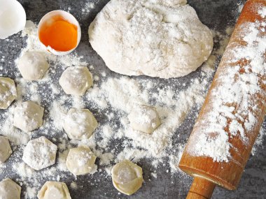 Hamur köftesi pişirme işlemi. Çiğ hamur, merdane, un, masada çiğ hamur..