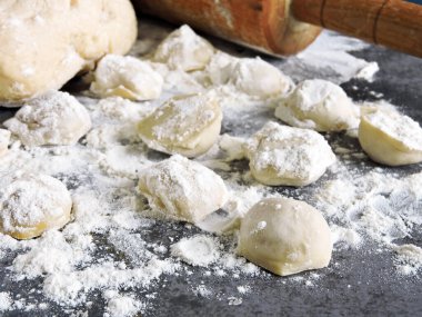 Hamur köftesi pişirme işlemi. Çiğ hamur, merdane, un, masada çiğ hamur..