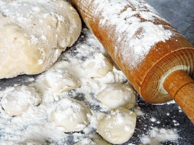 Hamur köftesi pişirme işlemi. Çiğ hamur, merdane, un, masada çiğ hamur..