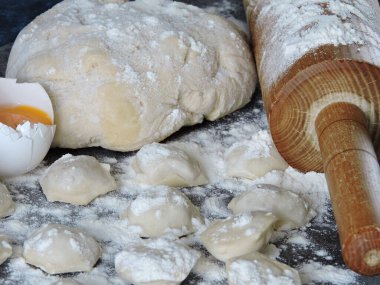 Hamur köftesi pişirme işlemi. Çiğ hamur, merdane, un, masada çiğ hamur..