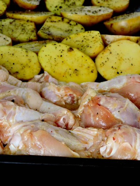 生のジャガイモと鶏の足と翼をベーキングシートの上に 焼きジャガイモとチキンを — ストック写真