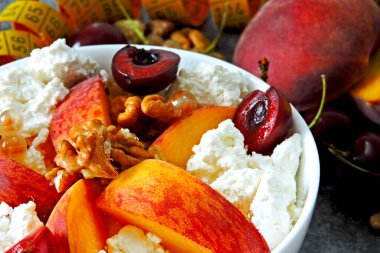 Beyaz kasede meyve ve böğürtlenli süzme peynir. Ölçüm bandı. Sağlıklı beslenme kavramı. Süzme peynir. Probiyotik. Fermente edilmiş süt ürünleri.