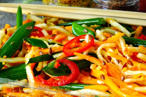 Salad from marinated vegetables with green onions in Chinese style. Fermented vegetables. Salad of fermented carrots and celery with green onions and chili peppers. Spicy Chinese salad. Food sticks.