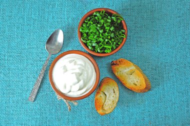 Ekşi kremalı ve yeşillikli kızarmış ekmek. Doğranmış yeşil soğan ve ekşi krema. Ekşi krema. Mayalanmış süt ürünü. Probiyotikler.