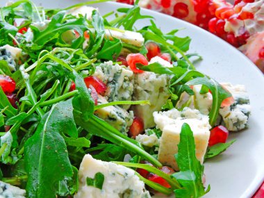 Gorgonzola peynirli ve nar aromalı Arugula salatası. Peynirli Dor Blue, roka ve bir parça nar. Lezzetli ve sağlıklı nar salatası..