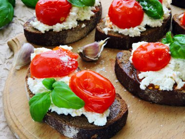 Ricotta peynirli fesleğen ve kiraz domatesli iştah açıcı bruschetta..