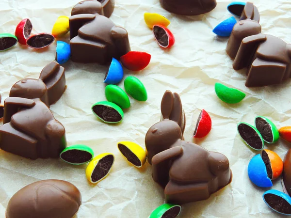 Chocolate rabbits, chocolate eggs and colorful candy as background. Easter mood.