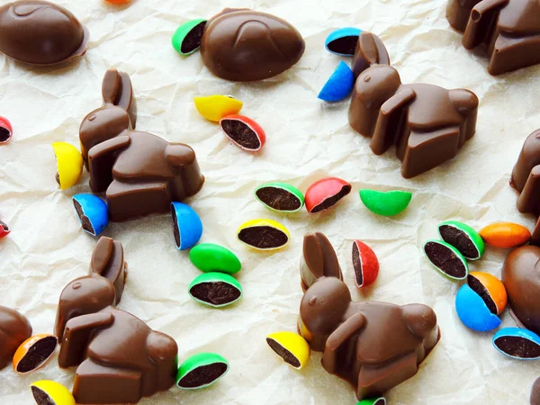 Chocolate rabbits, chocolate eggs and colorful candy as background. Easter mood.