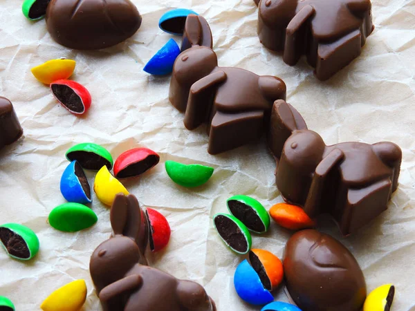 Chocolate rabbits, chocolate eggs and colorful candy as background. Easter mood.