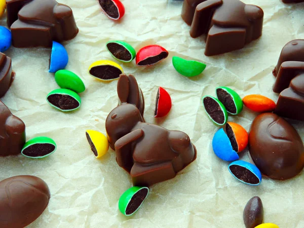 Chocolate rabbits, chocolate eggs and colorful candy as background. Easter mood.