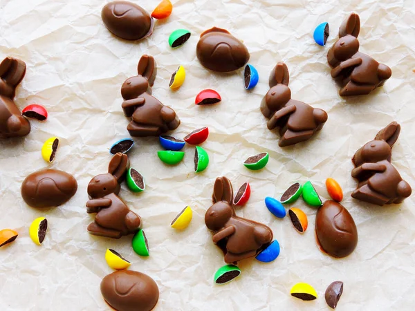 Chocolate rabbits, chocolate eggs and colorful candy as background. Easter mood.