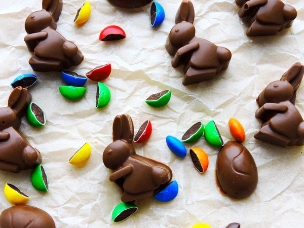 Chocolate rabbits, chocolate eggs and colorful candy as background. Easter mood.