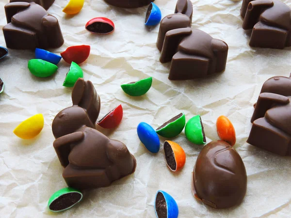 Chocolate rabbits, chocolate eggs and colorful candy as background. Easter mood.