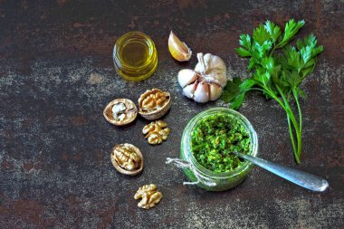 Maydanozlu ceviz pesto. Kavanozda ev yapımı pesto sosu. Üst Manzara. Ceviz ve maydanozlu vejetaryen pesto..