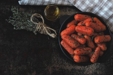 Dökme demir tavada kekik ile pişirilmiş bebek havuçları. Vejetaryen yemeği.