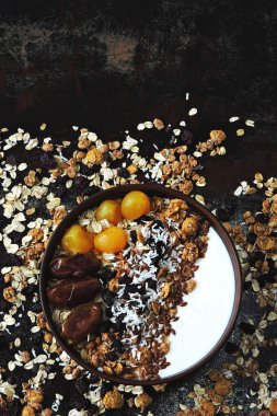 Sağlıklı bir kahvaltı kasesi dolusu tohum, hurma, kurutulmuş meyve ve granola..