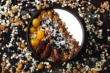 Sağlıklı bir kahvaltı kasesi dolusu tohum, hurma, kurutulmuş meyve ve granola..
