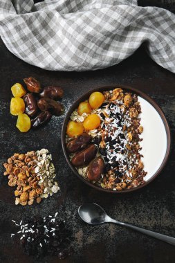 Sağlıklı bir kahvaltı kasesi dolusu tohum, hurma, kurutulmuş meyve ve granola..