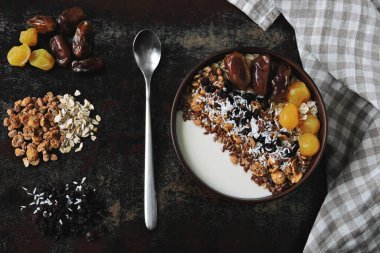 Sağlıklı bir kahvaltı kasesi dolusu tohum, hurma, kurutulmuş meyve ve granola..