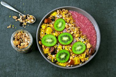 Arkaplanda granola ve kivi olan Bright Acai kasesi..