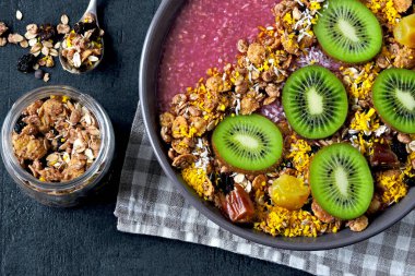 Arkaplanda granola ve kivi olan Bright Acai kasesi..