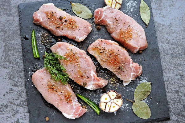 石板にニンニクとスパイスと生のポークステーキ 肉を調理するという概念 食事だよ パレオダイエット ペガン食 — ストック写真