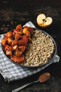 Yulaf ezmeli sıcak kış kahvaltısı, tarçınlı elma, kuru üzüm ve bal. Çevre yemeği. Superfood Fitness Kahvaltı yulaf ezmesi Tarçın elması.