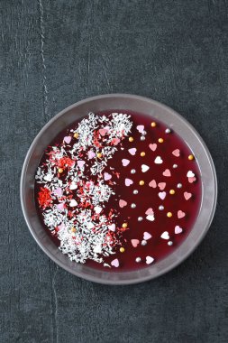 Sevgililer Günü için kahvaltı ya da tatlı. Tatlı kalpli ve süslemeli kırmızı marmelat kasesi. Romantik sağlıklı yiyecekler.