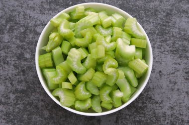 Bir kasede doğranmış kereviz sapı. Diyet ve uygun beslenme için ürünler.