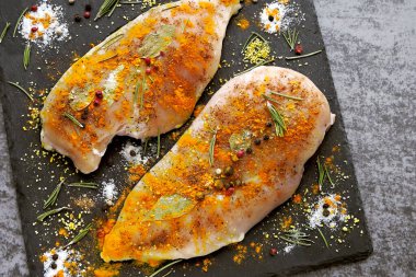 Çiğ tavuklu fileto, zerdeçal ve baharatlı taş bir tahtada marine edilmiş. Üst Manzara. Köri pişiriyorum..