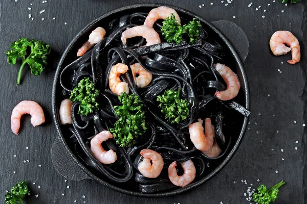 Black pasta with shrimps. Black food. Food trend. Vegetarian lunch.