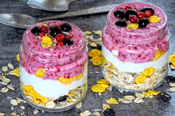 Böğürtlenli yoğurt, gevrek ve böğürtlen. Sağlıklı meyve suyu ve yoğurt dolu kavanozlar. Mor Smoothie Keto kahvaltısı ya da tatlı. Keto diyeti.