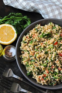 Kâse içinde Arap salatası tabağı. Orta Doğu mutfağı. Bulgur, maydanoz ve sebzeli sağlıklı salata. Bulgur 'lu vejetaryen salatası. Tabouli salatası.