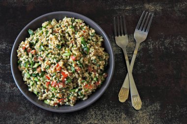Kâse içinde Arap salatası tabağı. Orta Doğu mutfağı. Bulgur, maydanoz ve sebzeli sağlıklı salata. Bulgur 'lu vejetaryen salatası. Tabouli salatası.