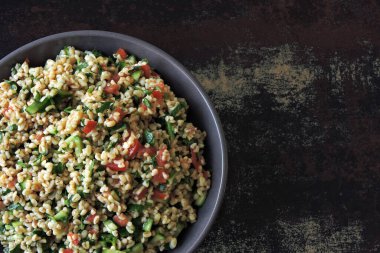 Kâse içinde Arap salatası tabağı. Orta Doğu mutfağı. Bulgur, maydanoz ve sebzeli sağlıklı salata. Bulgur 'lu vejetaryen salatası. Tabouli salatası.