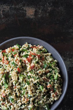 Kâse içinde Arap salatası tabağı. Orta Doğu mutfağı. Bulgur, maydanoz ve sebzeli sağlıklı salata. Bulgur 'lu vejetaryen salatası. Tabouli salatası.