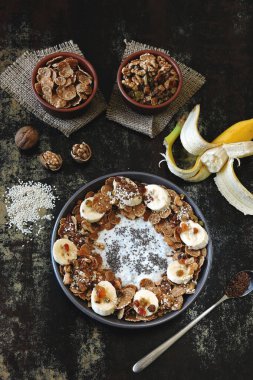 Sağlıklı kahvaltı kasesi. Bir kase chia yoğurdu, muz, tohum ve mısır gevreği..