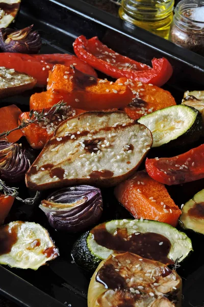 焼きカボチャ ズッキーニ パプリカ リンゴ ベーキングシート上のハーブやスパイスと青玉ねぎ 野菜や果物を混ぜます ビーガンランチ — ストック写真