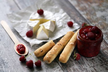 Ahududu soslu ve grossini çubuklu Camembert peyniri. Keto dost canlısı. İtalyan havası. Seçici odaklanma. Makro.
