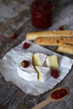Ahududu soslu ve grossini çubuklu Camembert peyniri. Keto dost canlısı. İtalyan havası. Seçici odaklanma. Makro.