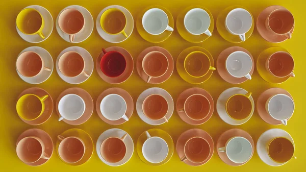 Muchas tazas de colores sobre fondo amarillo - 3D renderizado — Foto de Stock
