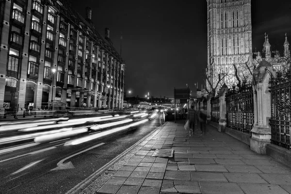 light trails and traditional buildings in Westminster at night, London, UK